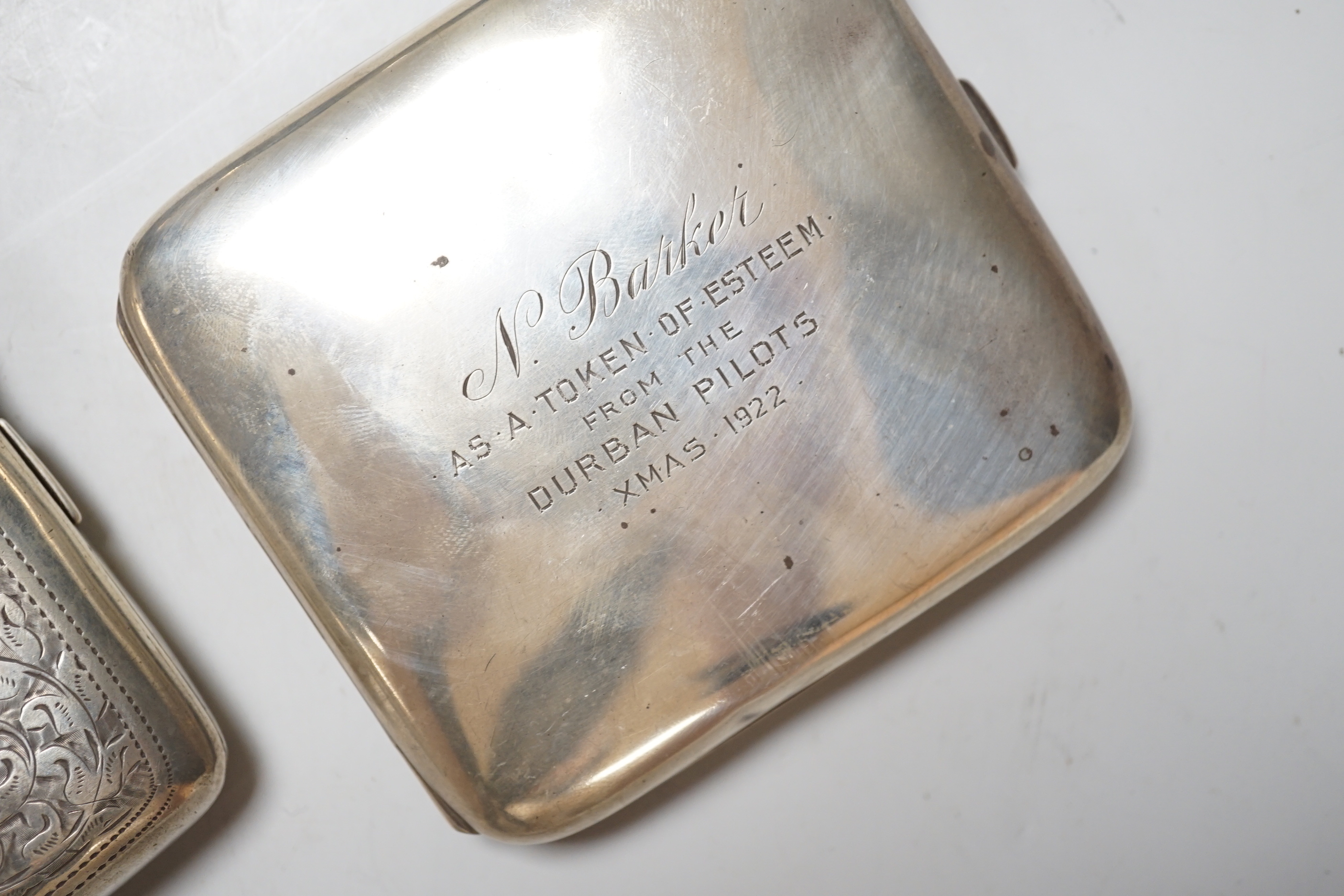 An Edwardian engraved silver cigarette case, 1901, 76 grams, a George V cigarette case with inscription from the Durban Pilots 1922, 102 grams and a cased set of six George V teaspoons, 58 grams